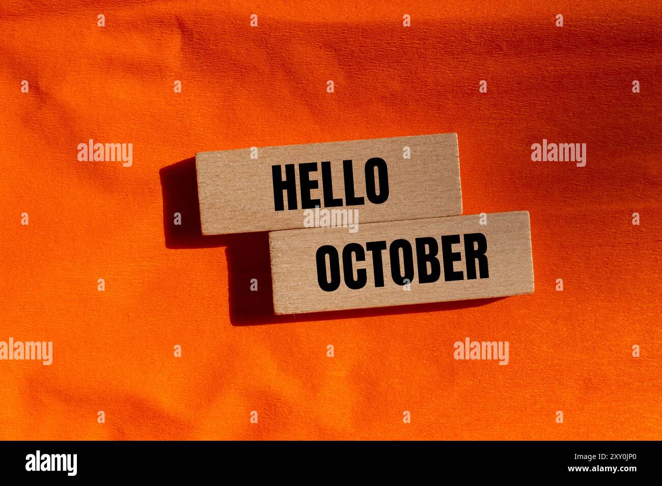 Hello october message written on wooden blocks with orange background. Conceptual hello october symbol. Copy space. Stock Photo