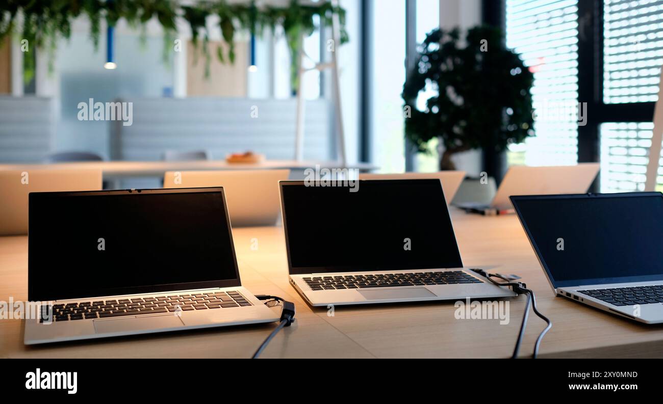 Laptops on a table in a co-working space Stock Photo - Alamy