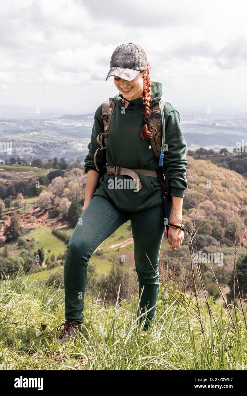 A joyful Caucasian female hiker in green attire explores a lush ...