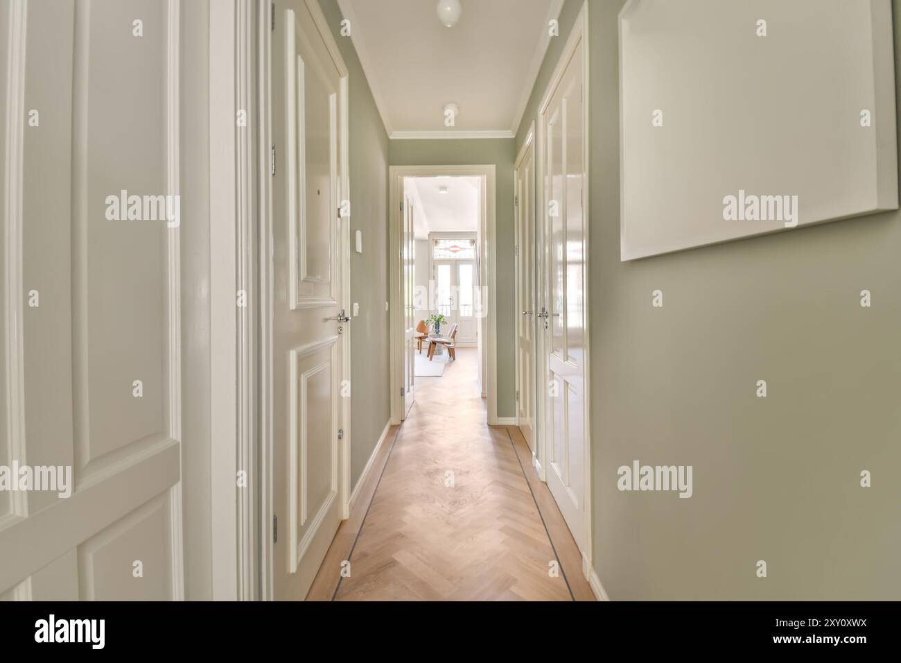 A contemporary home's hallway, bathed in natural light, featuring clean  lines, neutral tones, and stylish wooden flooring leading to a cozy room  Stock Photo - Alamy, image size:1300x956