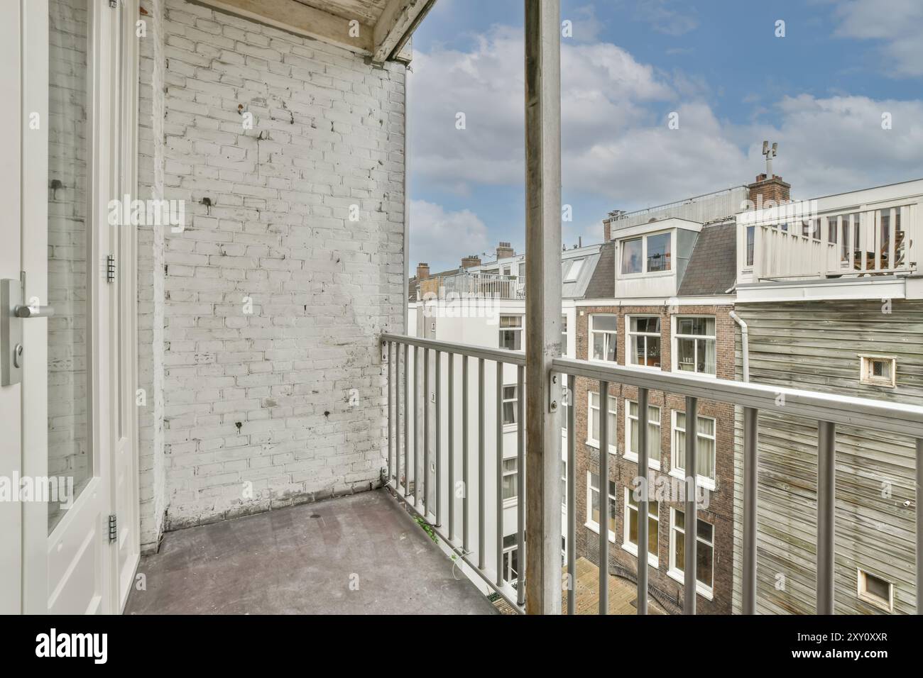 A cozy urban balcony featuring a white painted brick wall, iron railing ...