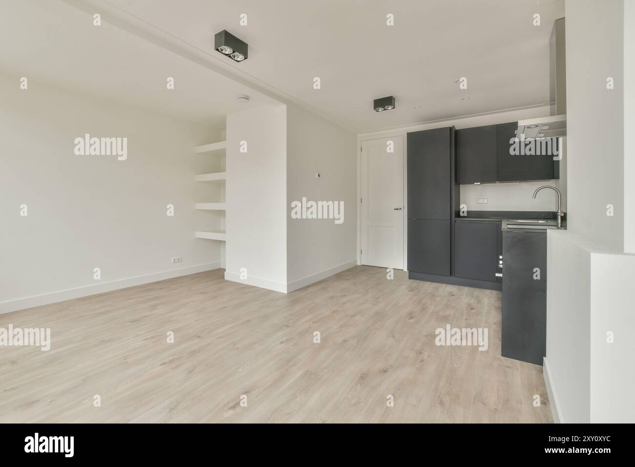 An empty modern interior featuring a combined kitchen and living space ...