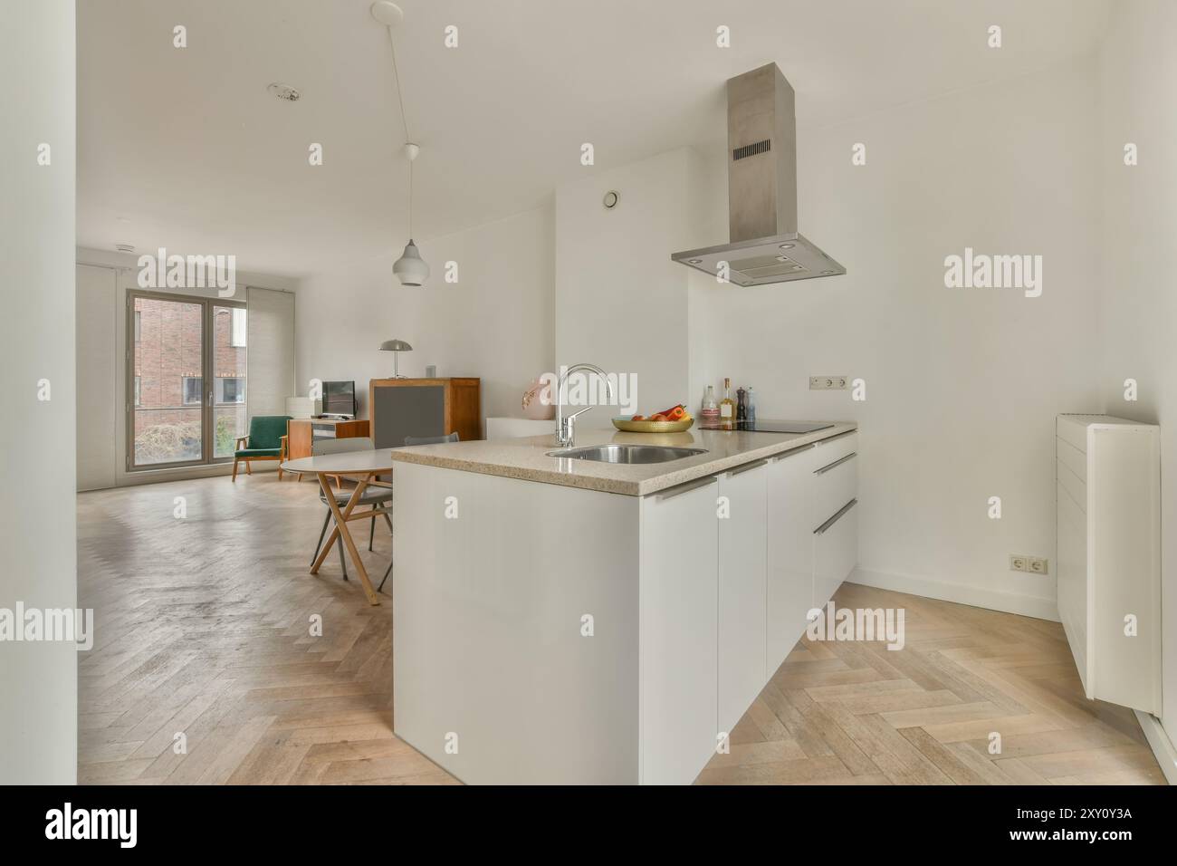 A contemporary, open-plan kitchen and dining space with clean white ...