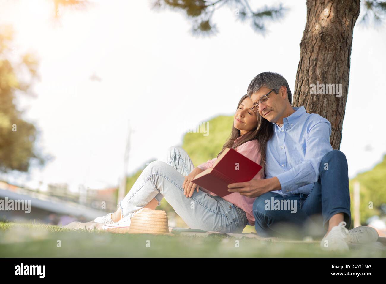 Couple reading under a tree hi-res stock photography and images - Alamy