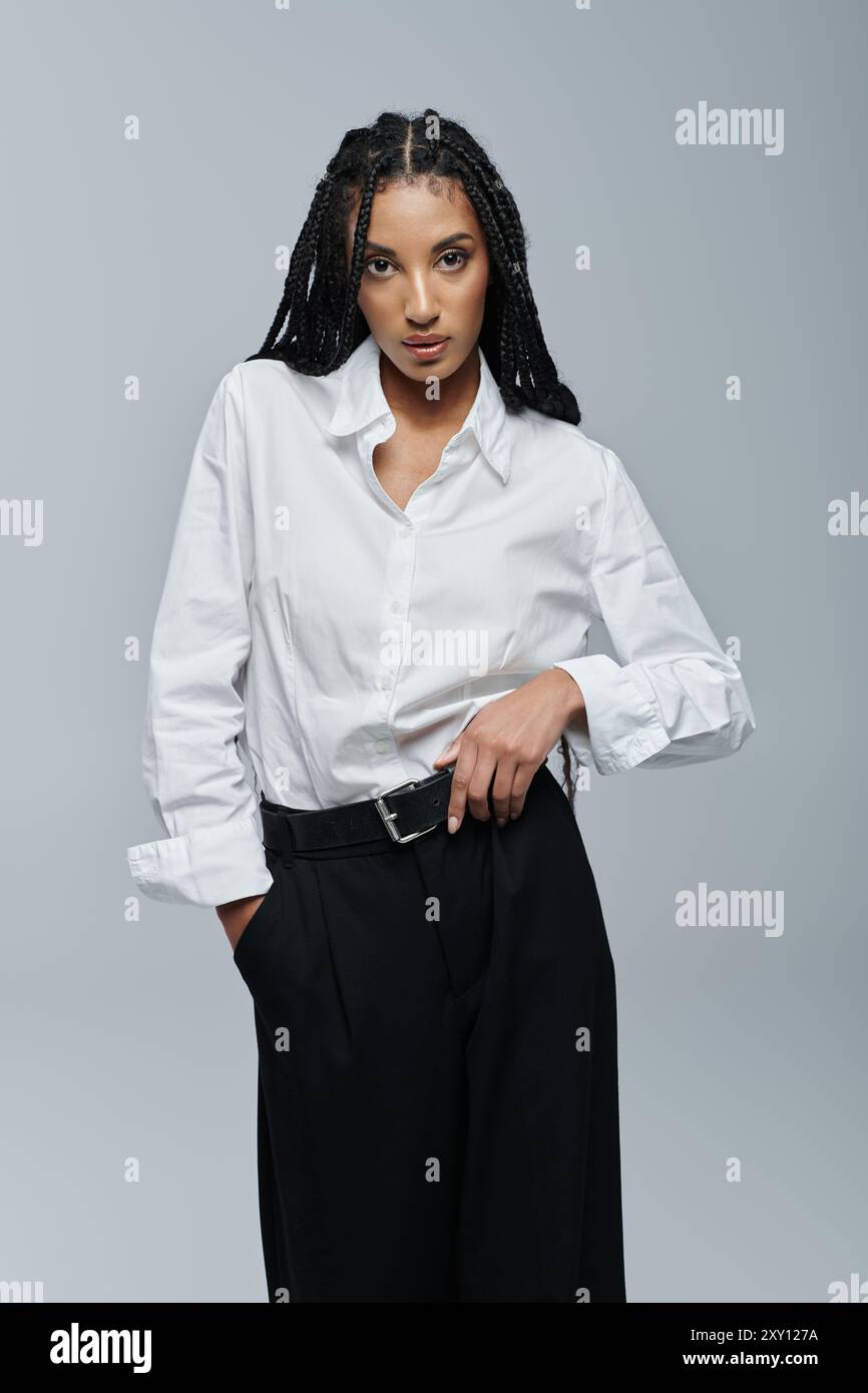 A young African American woman with braids poses in a white shirt ...