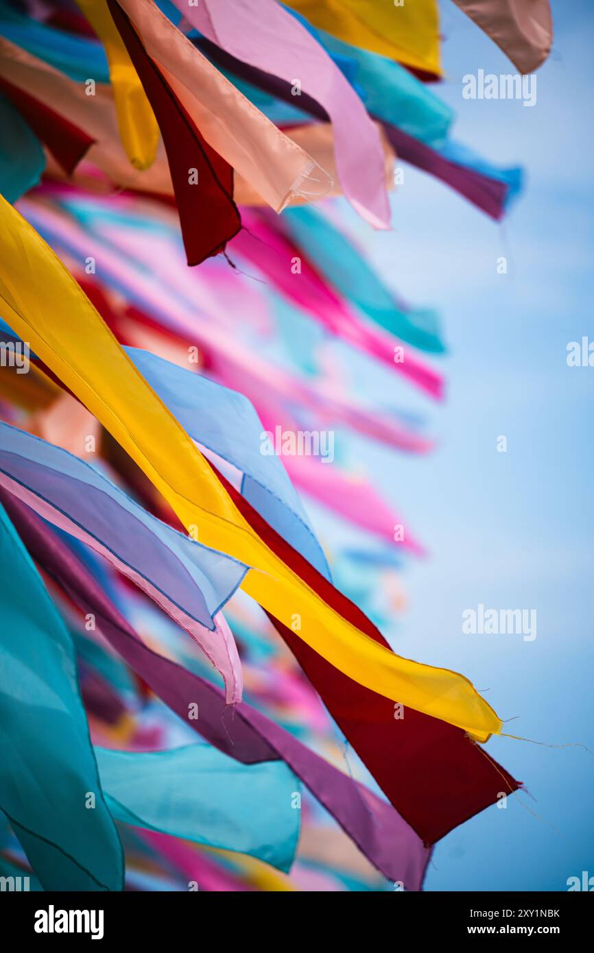 Color image of many colorful ribbons blown by the wind, against a blue ...