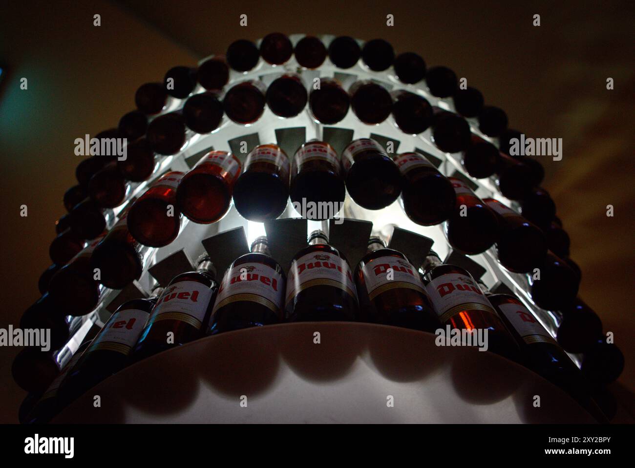 Duvel Beer Bottles Suspended in a Circular Display at Pub Stock Photo