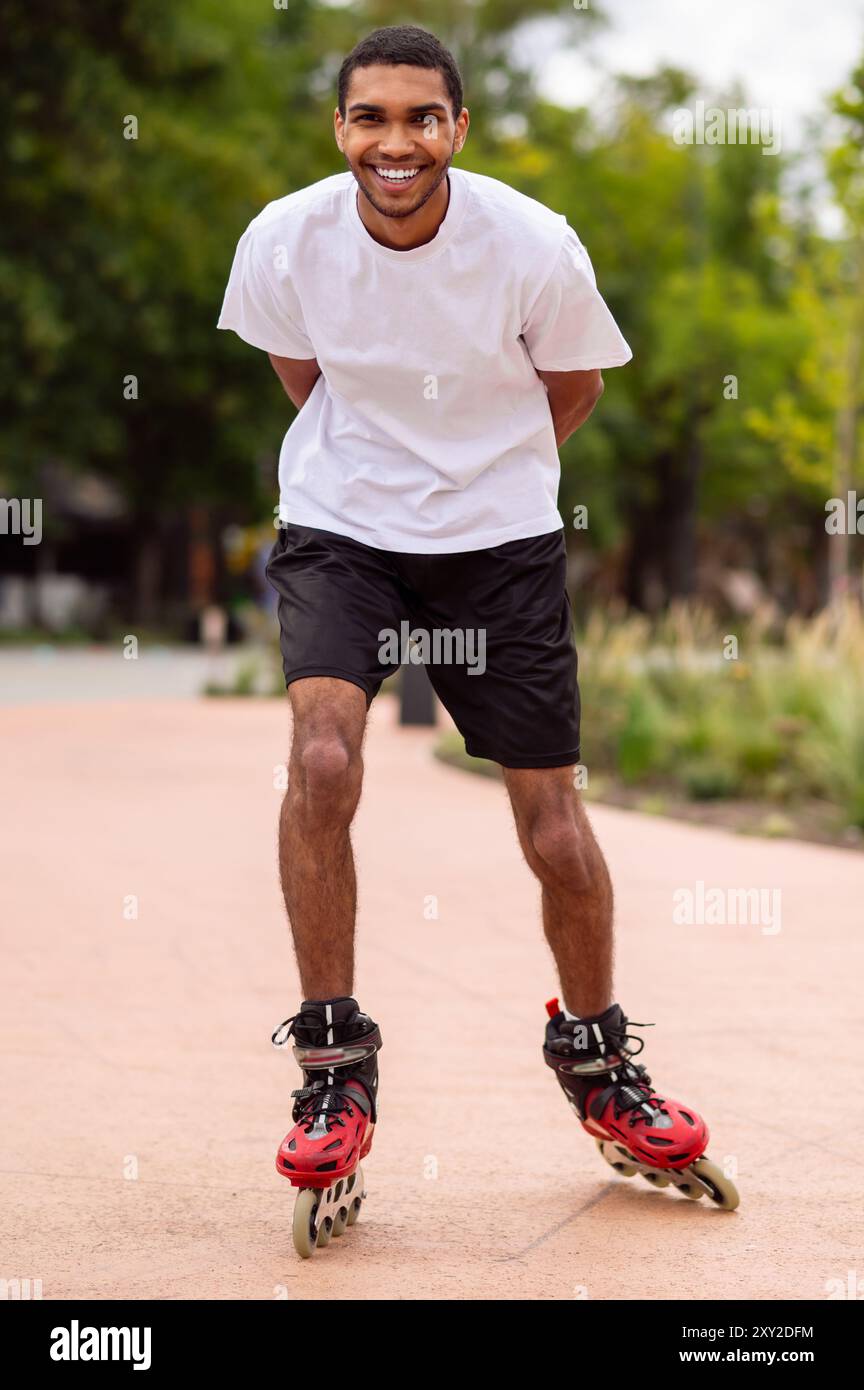 Tall dark-haired young man on rollers in the park having a ride Stock ...