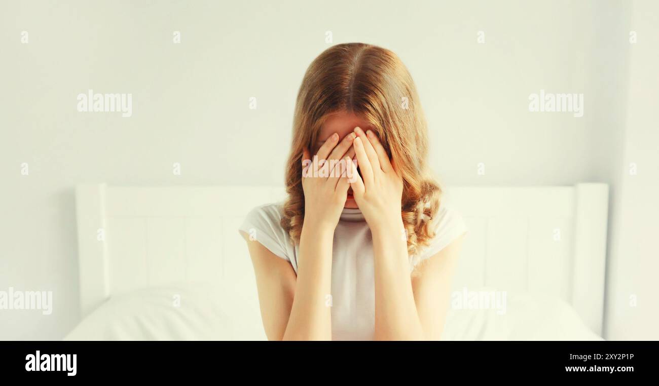 Portrait of upset sad crying woman covering her eyes with her hands ...