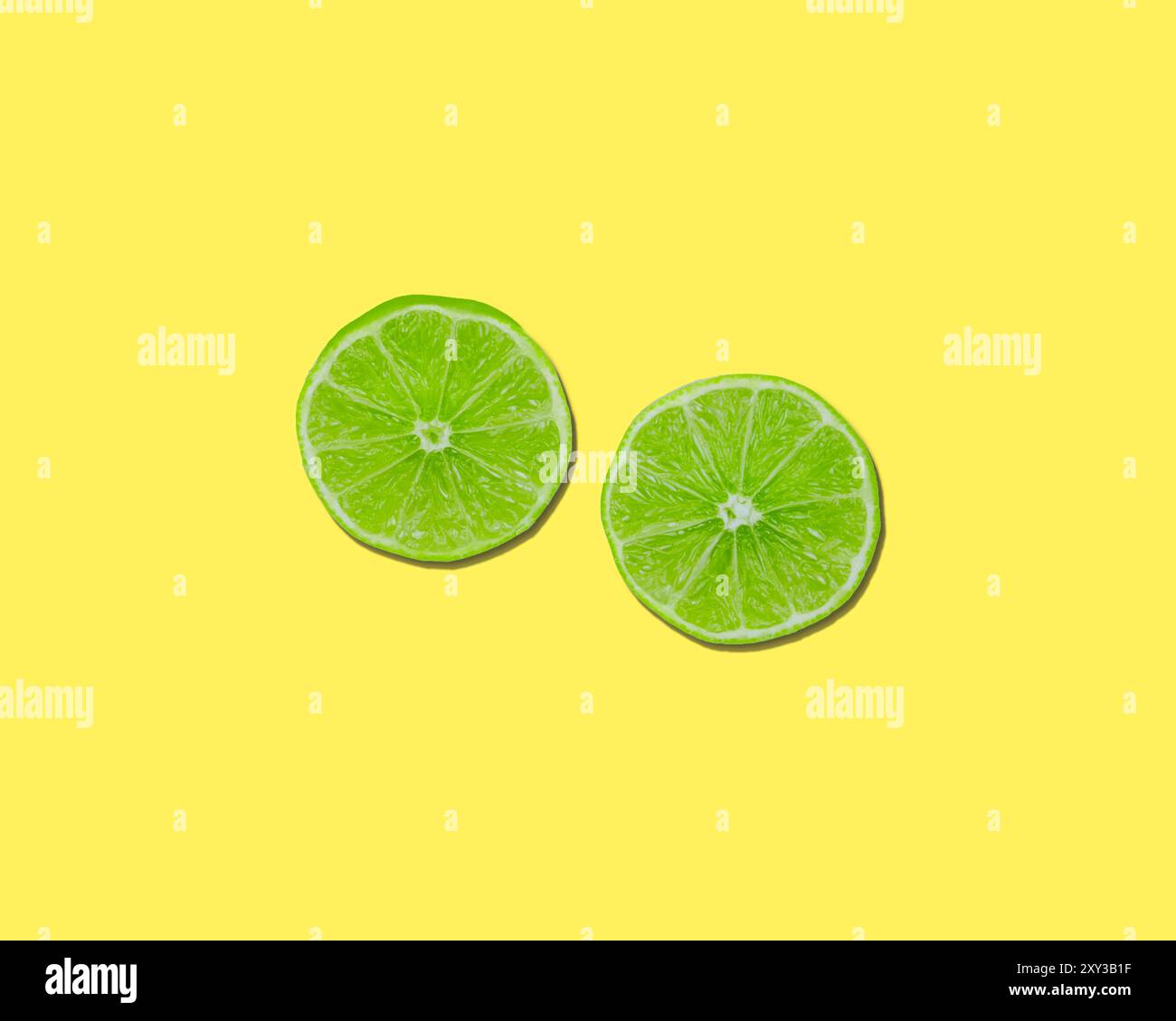 Green lime halves sliced on lemon yellow background Stock Photo - Alamy