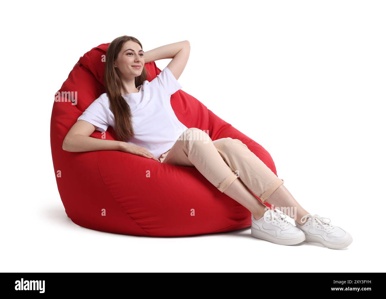 Beautiful young woman sitting on red bean bag chair against white ...