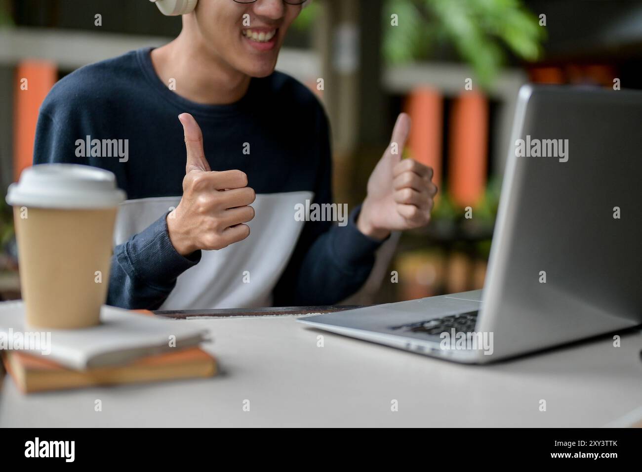 A cropped image of a cheerful, smiling young Asian male college student ...