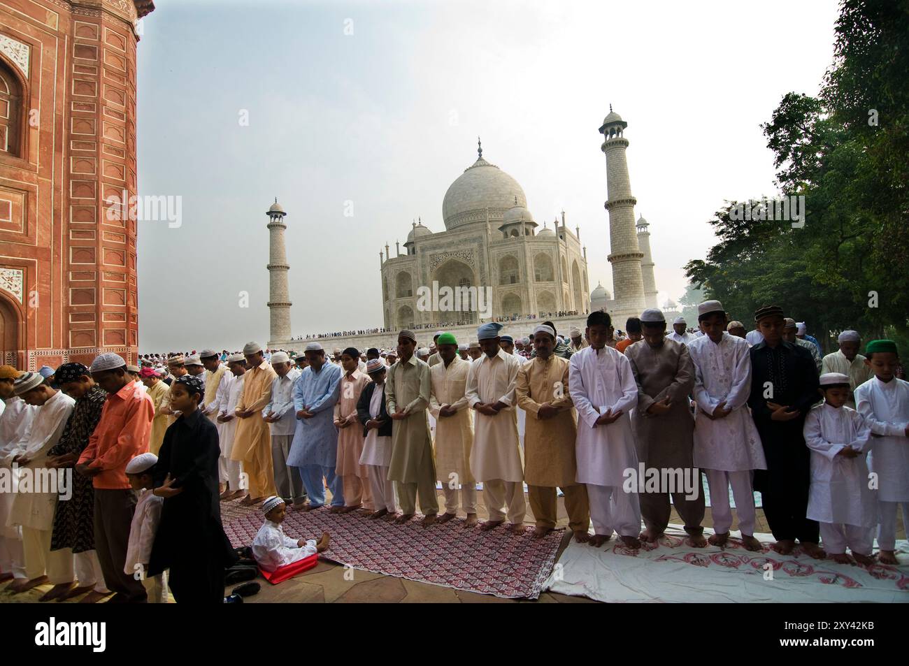 Muslim men pray by the mosque next to the Taj Mahal in Agra. Stock Photo