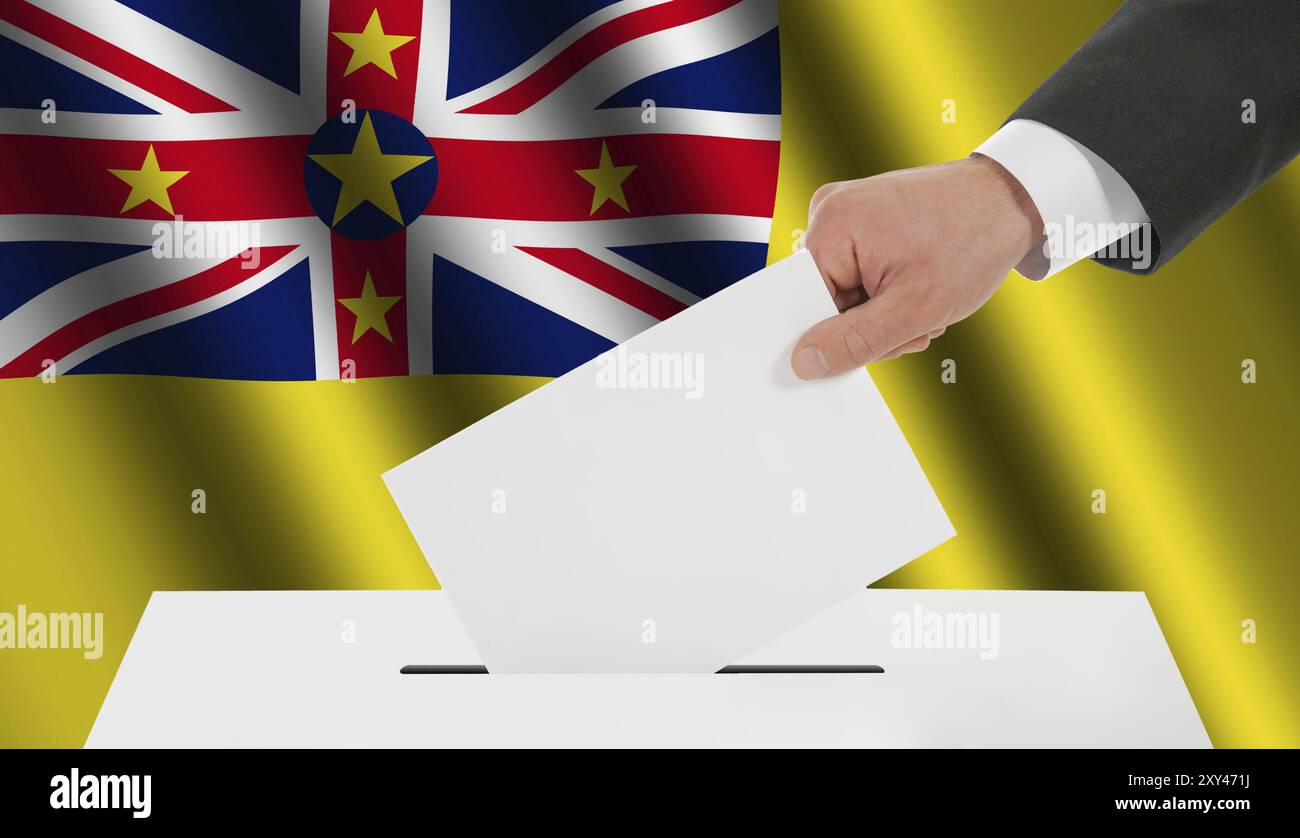 The Niuean flag and the hand with the bulletin about the ballot box Stock Photo