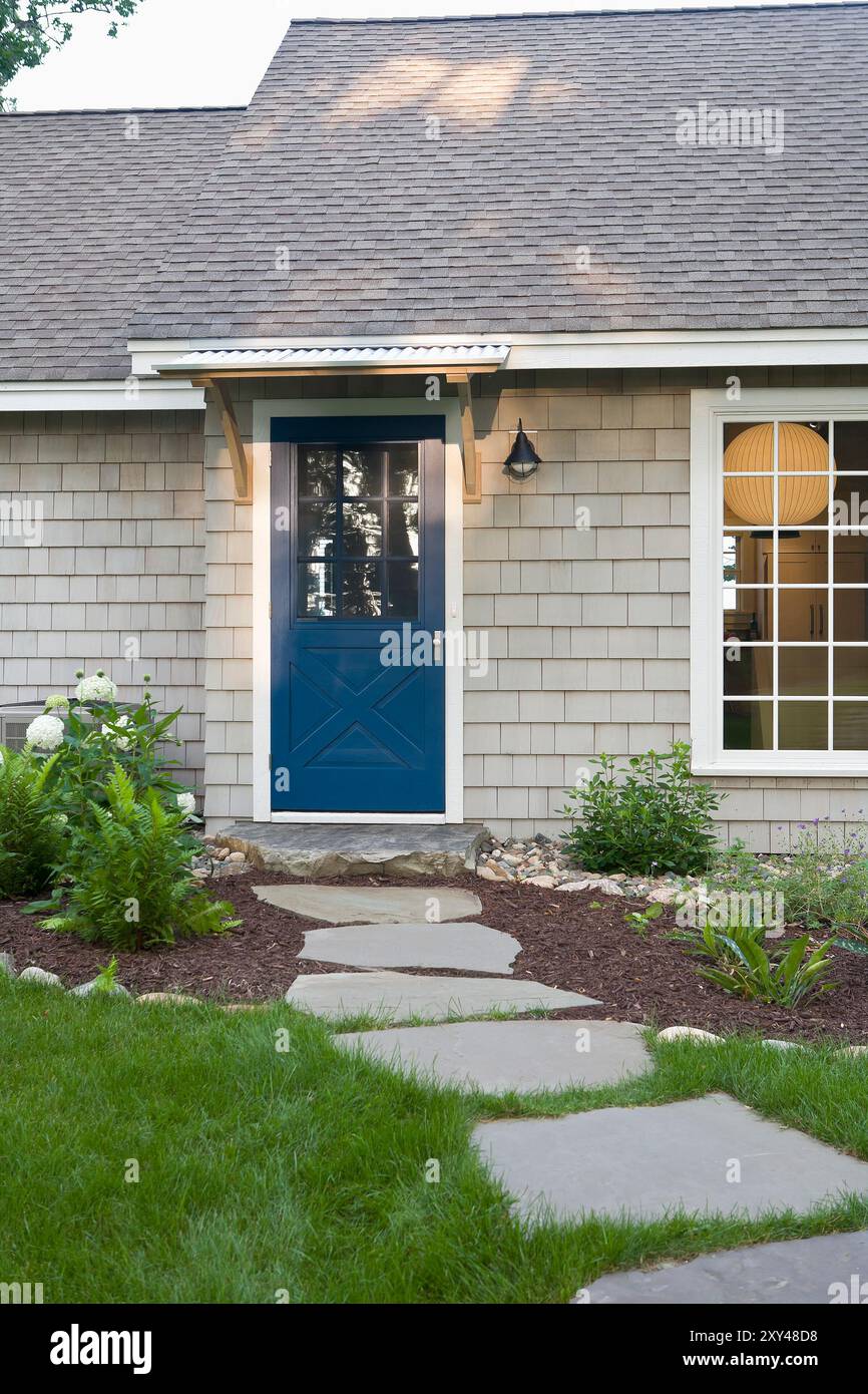 Stone pavers lead up to charming cottage with blue door Stock Photo - Alamy