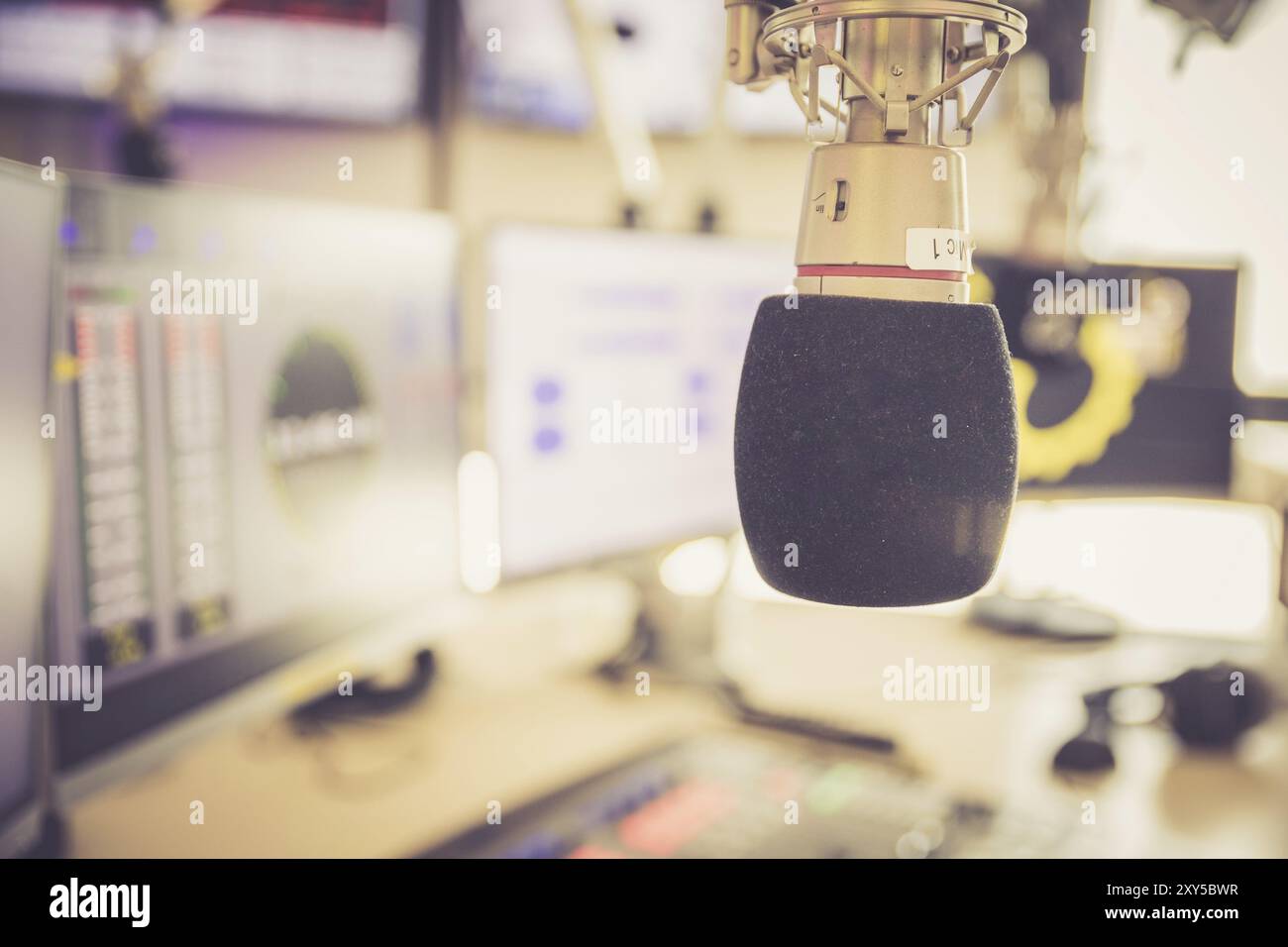 Studio microphone in a broadcasting radio studio, mixer and computer in ...