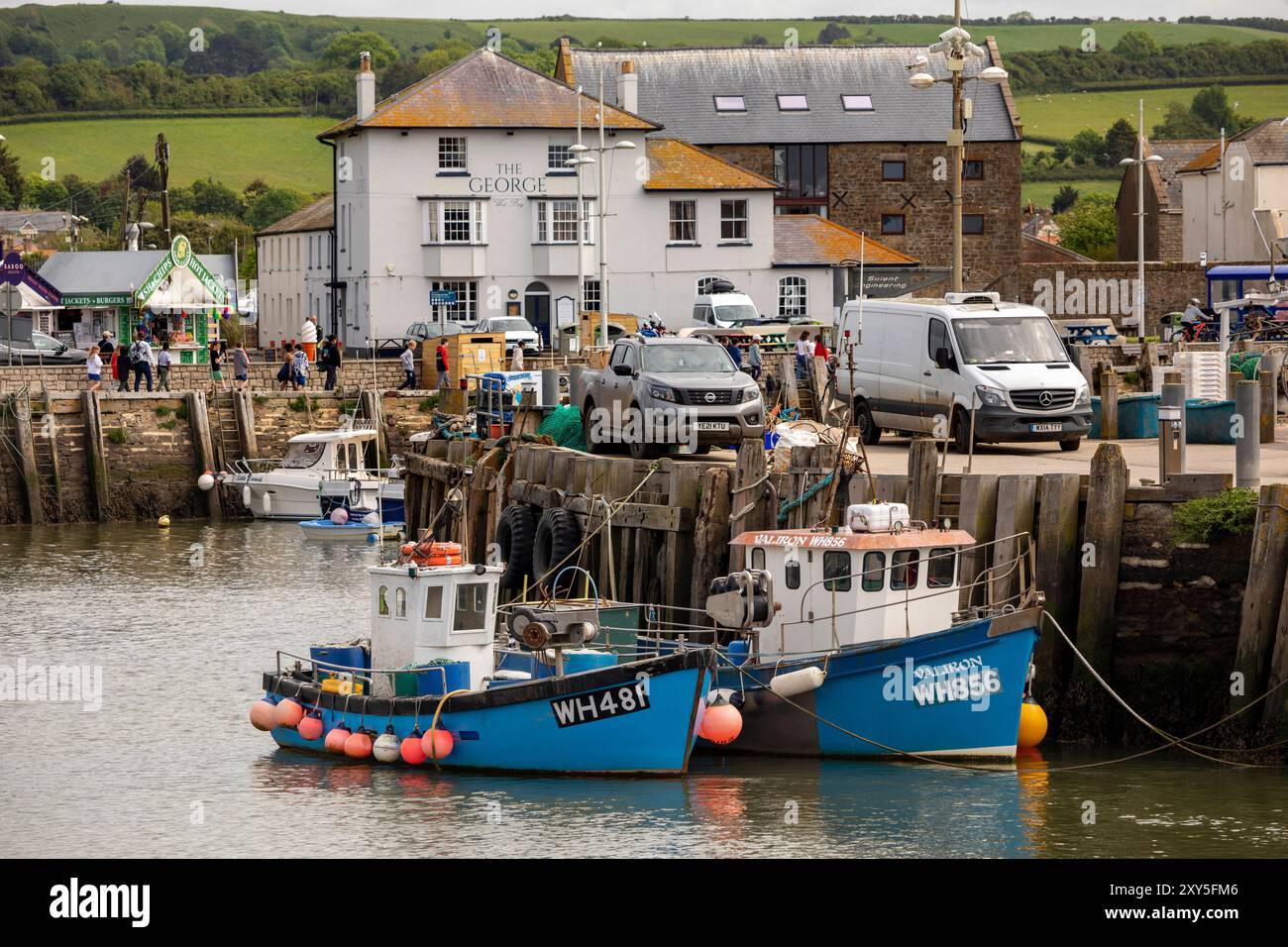 UK England, Dorset, Bridport, West Bay, fishing boats moored in harbour below George Pub Stock Photo