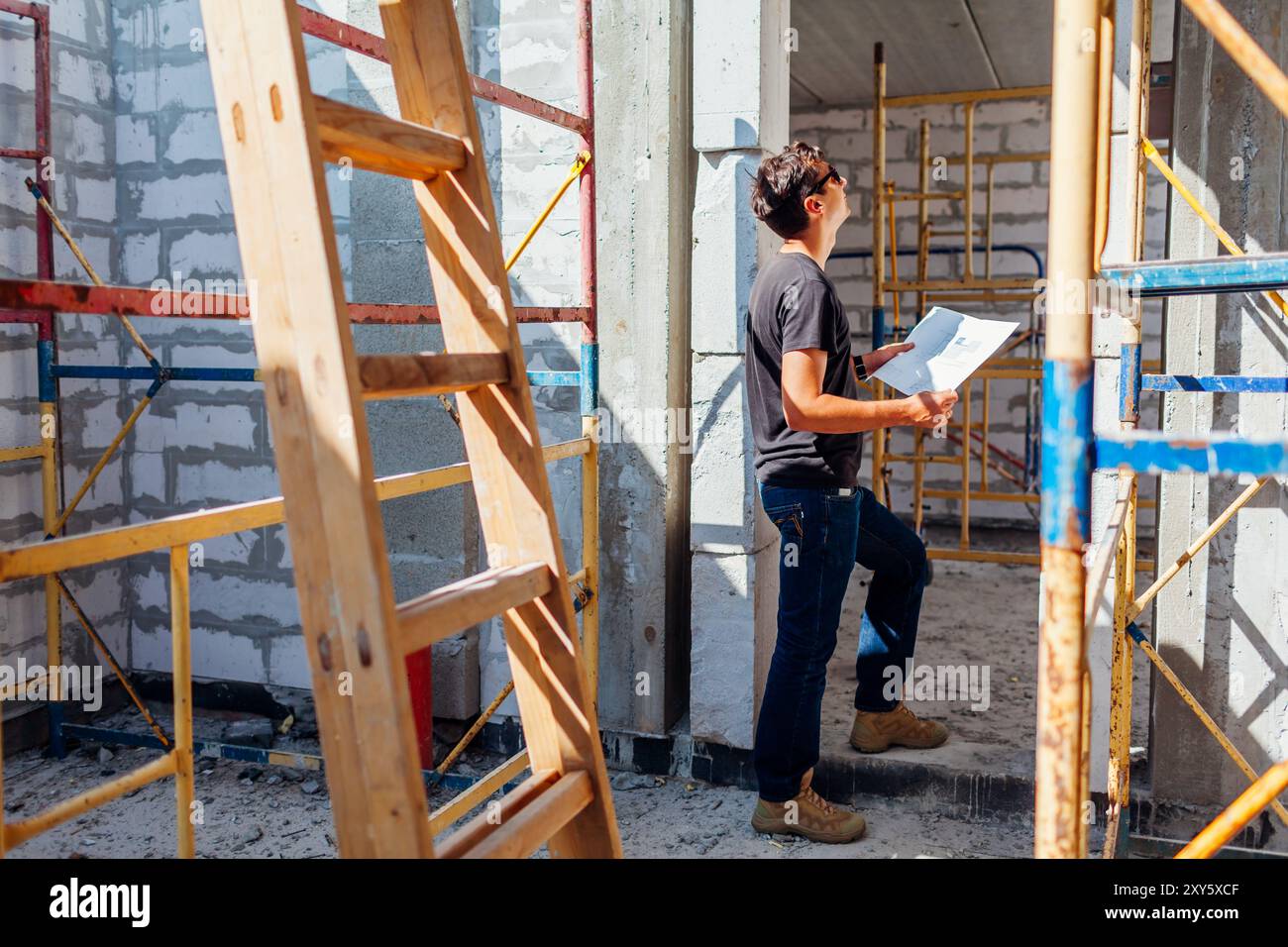 Man architect engineer checking house under construction comparing with ...