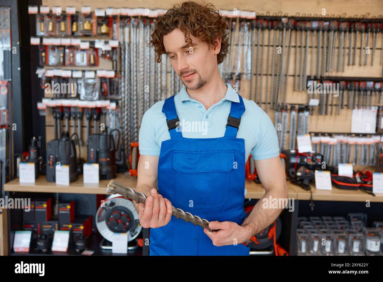 Man worker buying drill consumable tool to make holes in concrete at tools shop Stock Photo