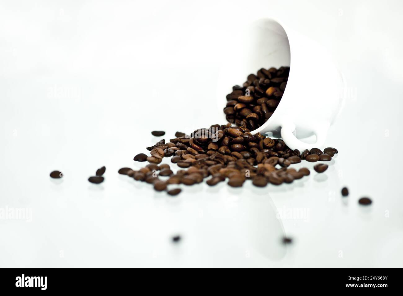Coffee beans fall out of a white cup Stock Photo - Alamy