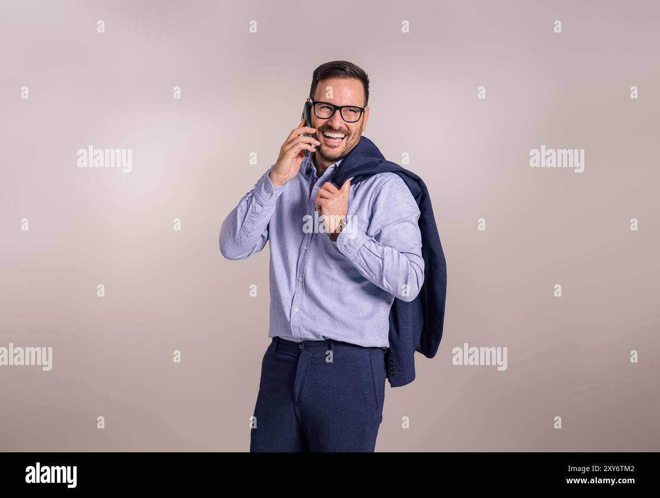 Successful happy businessman with blazer talking with client over mobile phone on white background Stock Photo