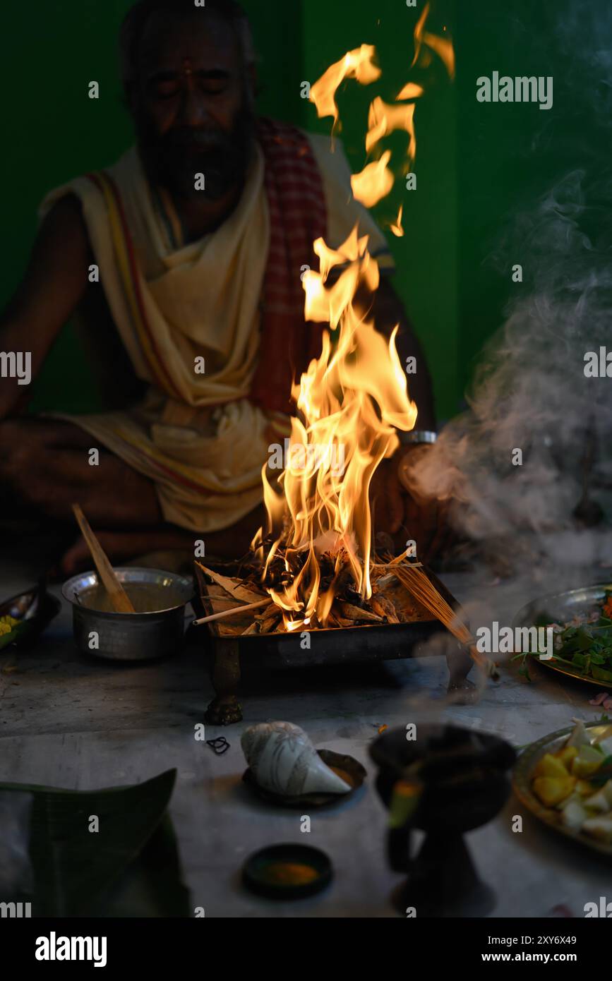 Brahmin performs the Yajna during puja, a traditional Hindu fire ritual. Kolkata, West Bengal, India on October 09, 2022 Stock Photo