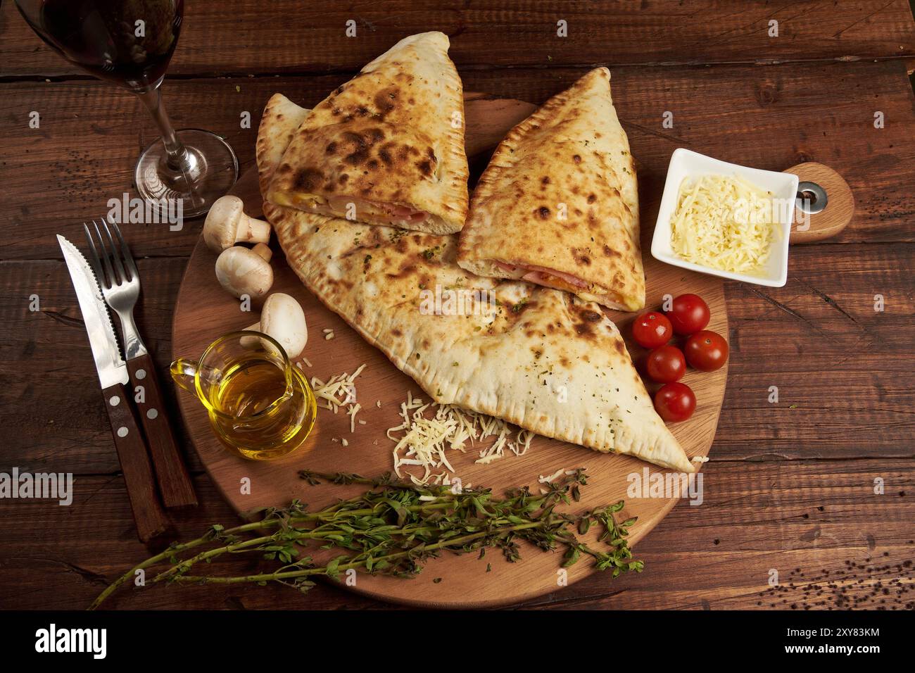 Calzone, traditional Italian preparation accompanied by spices and red ...