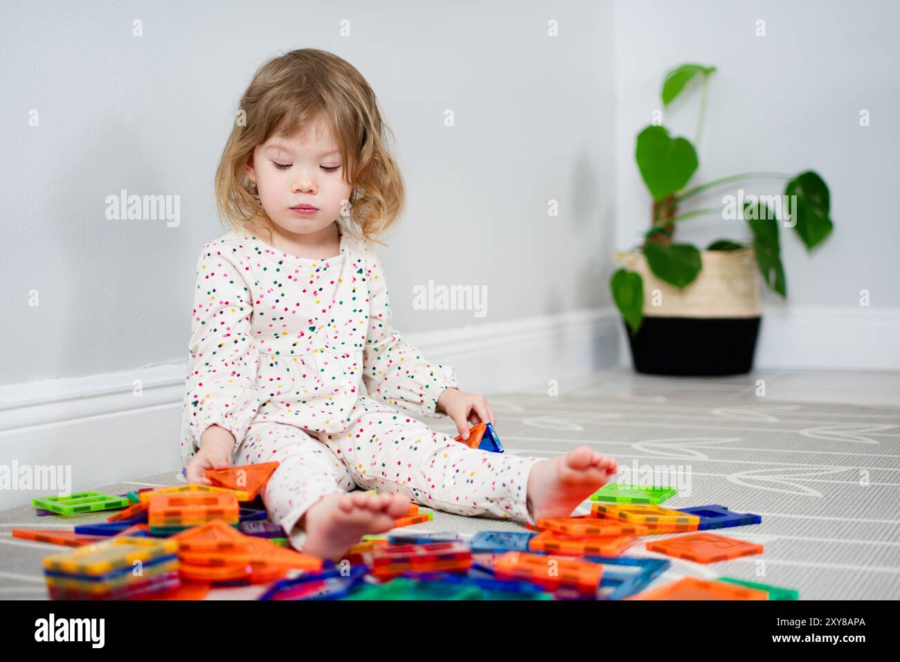 Little Caucasian Toddler girl playing with magnetic tiles. Magna tiles ...