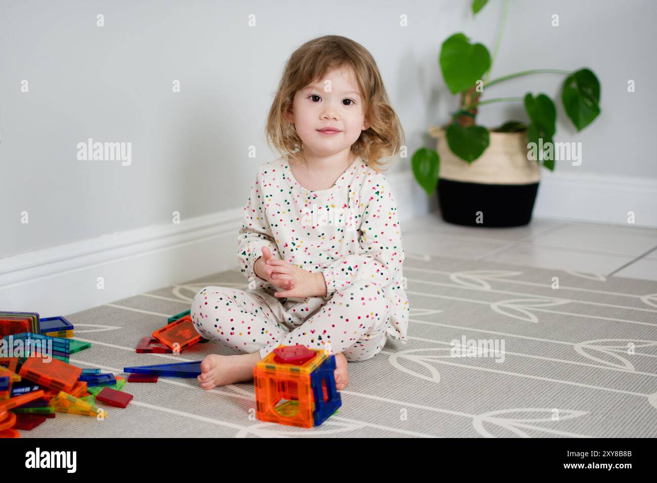 Little Caucasian Toddler girl playing with magnetic tiles. Magna tiles ...