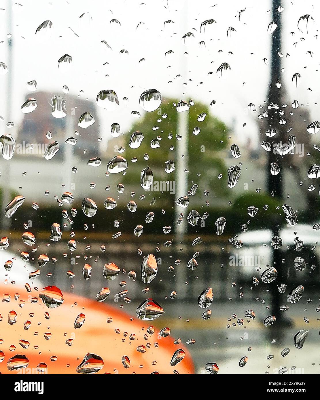 Raindrops on a car window with blurred cars on a city street, Shanghai, China. Travel and development concept. Stock Photo