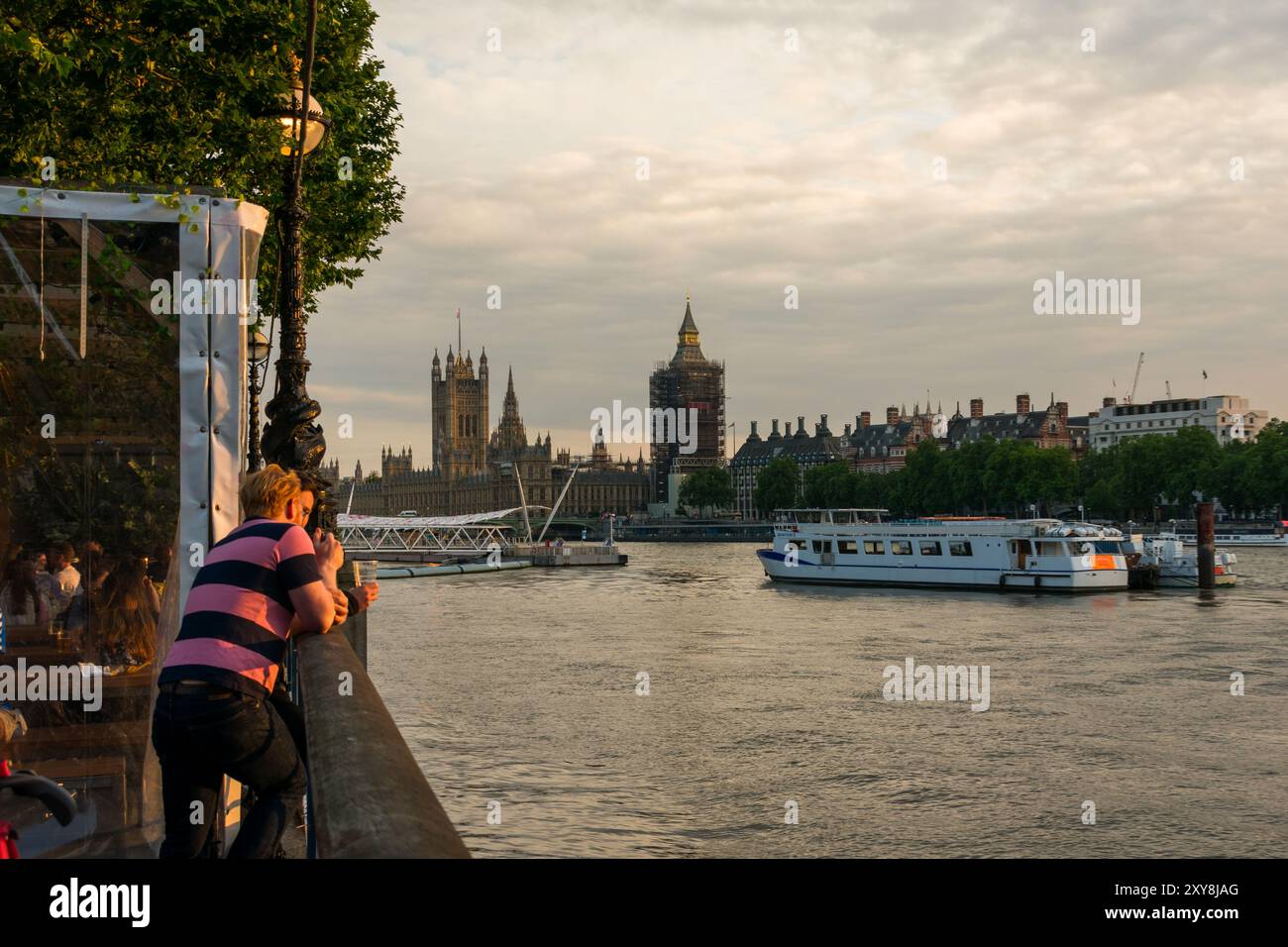 Golden Hour on the River Thames captures a serene moment overlooking Big Ben and the Houses of Parliament, as the city of London comes alive. Stock Photo