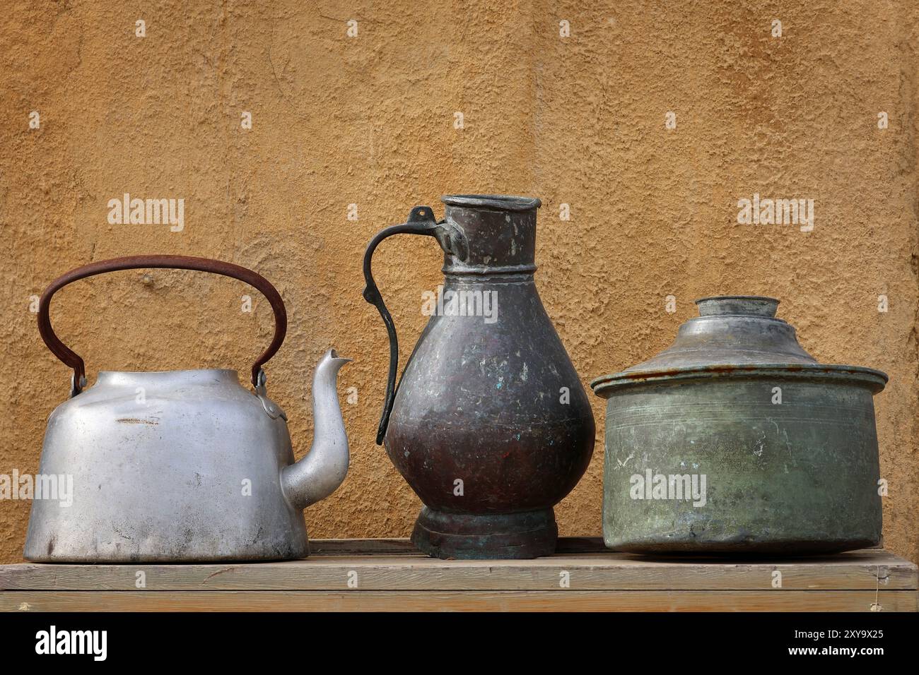 Various metallic pots displayed on a wooden table. Stock Photo