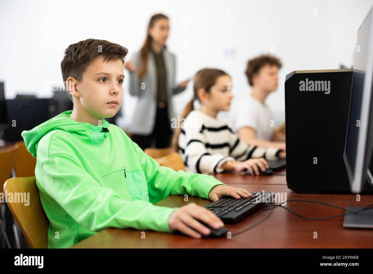 Young boy learning to use personal computer during lesson Stock Photo ...
