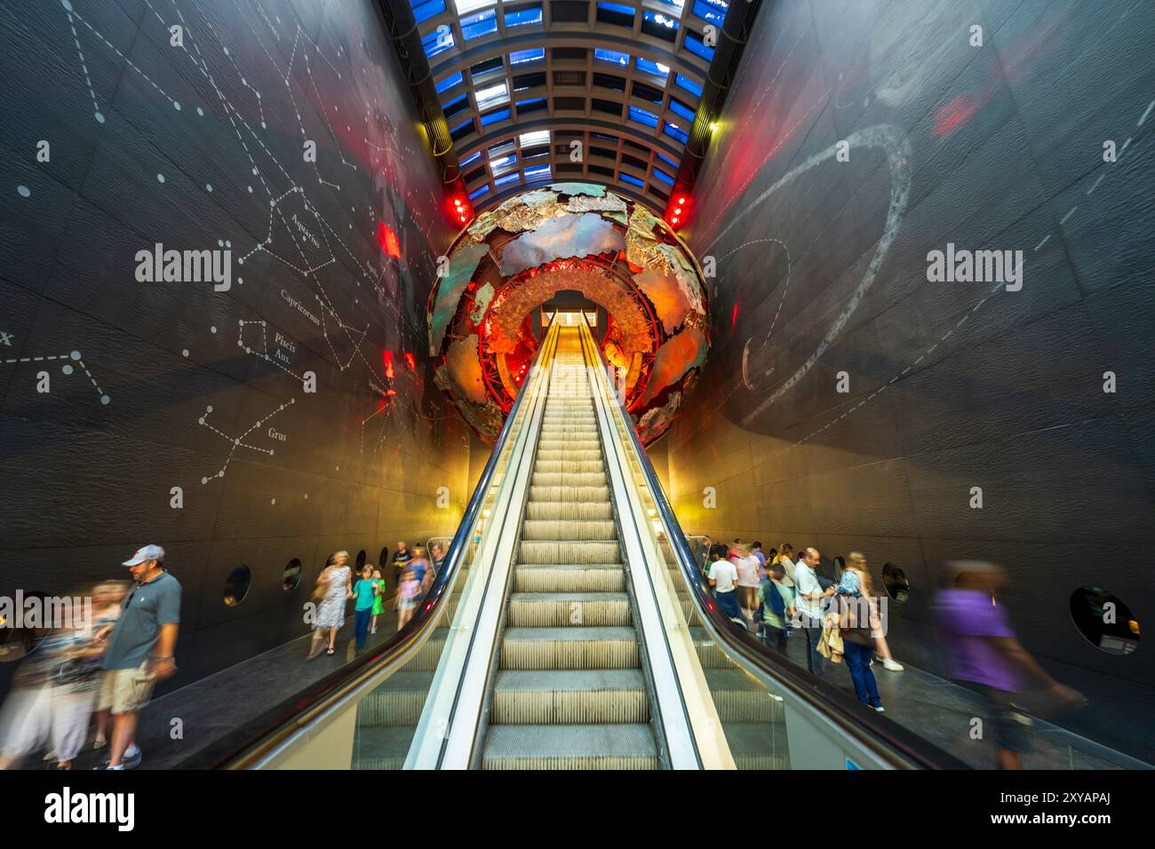 Inside London Natural History Museum. Iconic interior gallery entrance with a large world globe with neon lights and a long escalator in London, UK. Stock Photo