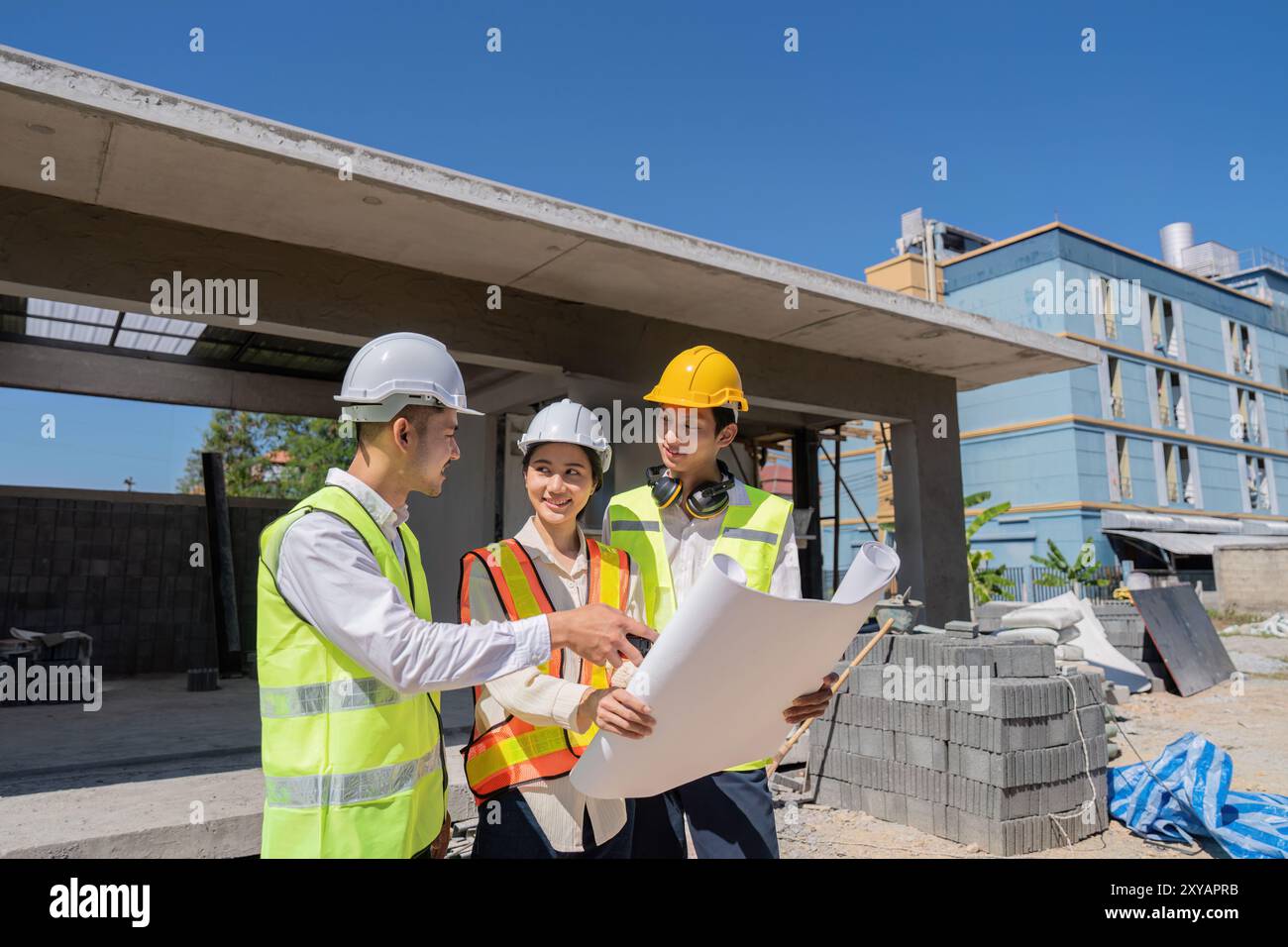 Engineers Collaborating on Construction Plans Outdoors. Teamwork and Development Stock Photo