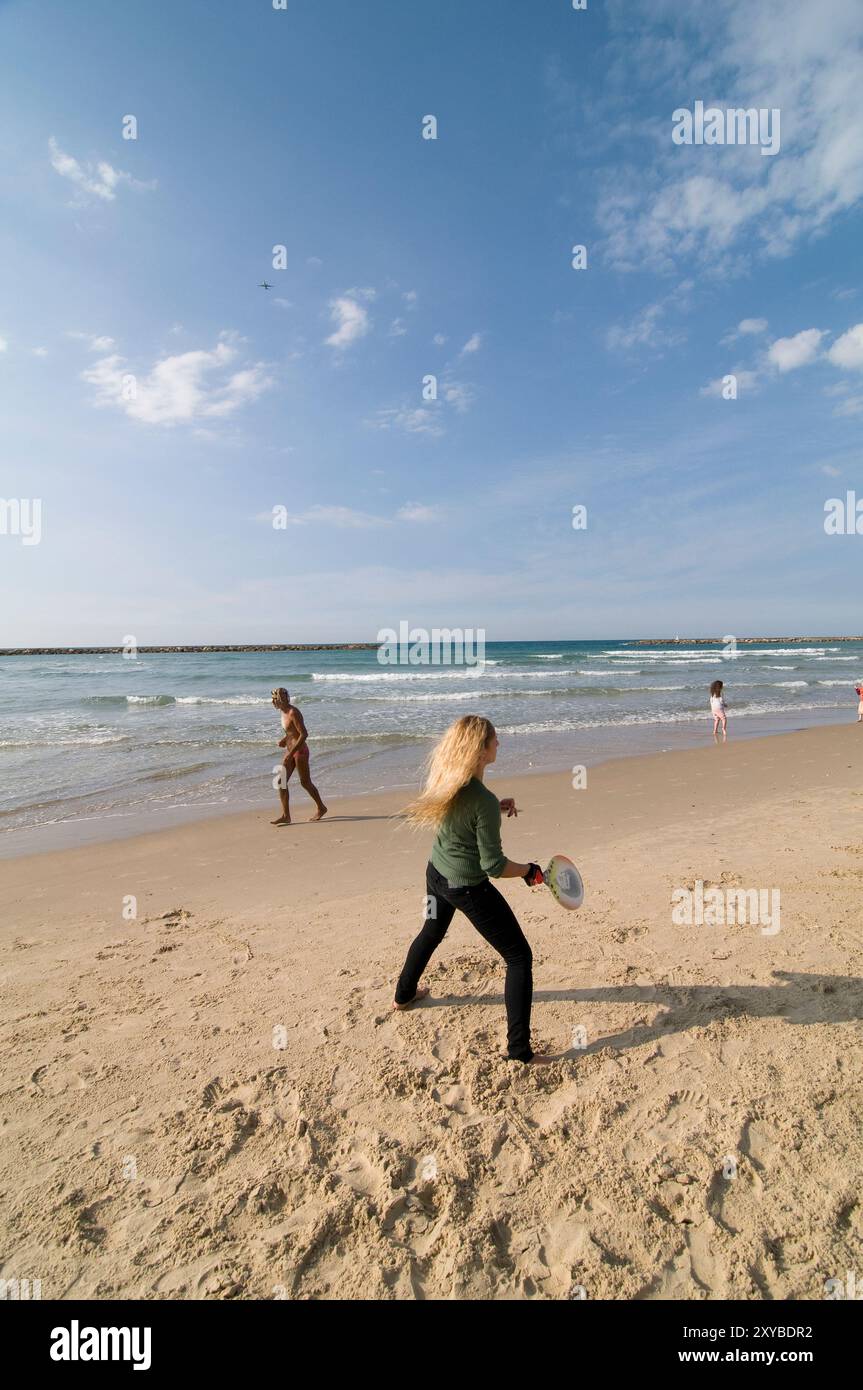 An Israeli woman playing ' Matkot ' - beach Tennis on a sunny winter day in tel Aviv, Israel. Stock Photo