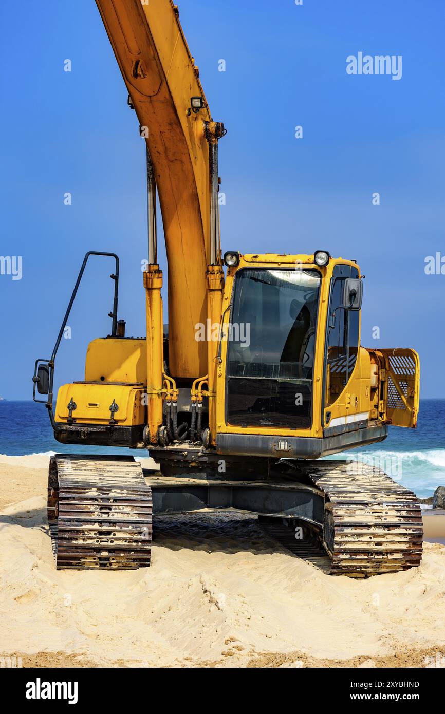 Yellow excavator cabin and arm over sand at beach in a sunny day Stock ...