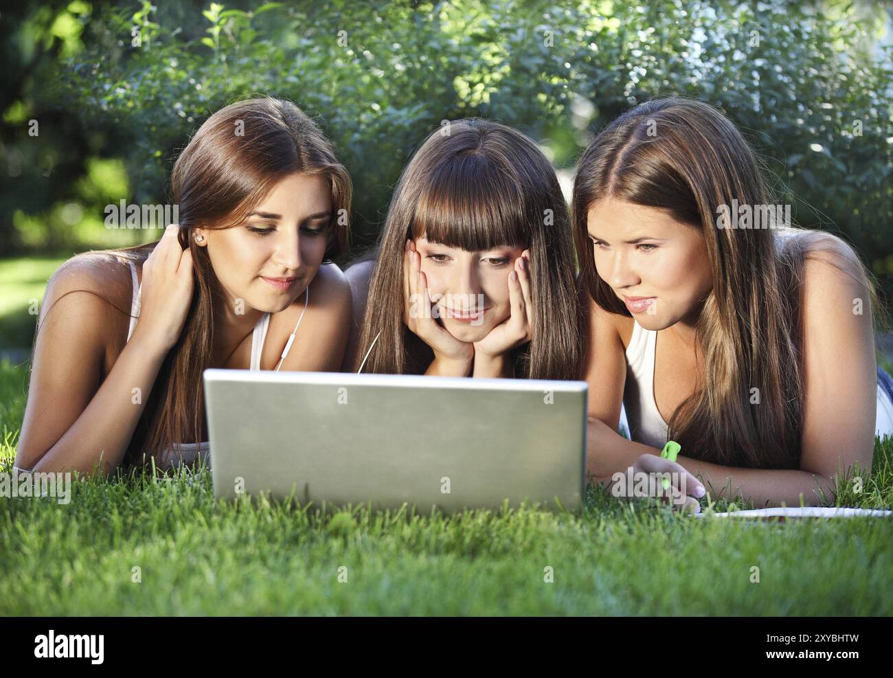 Happy young girls having fun using a notebook Stock Photo - Alamy