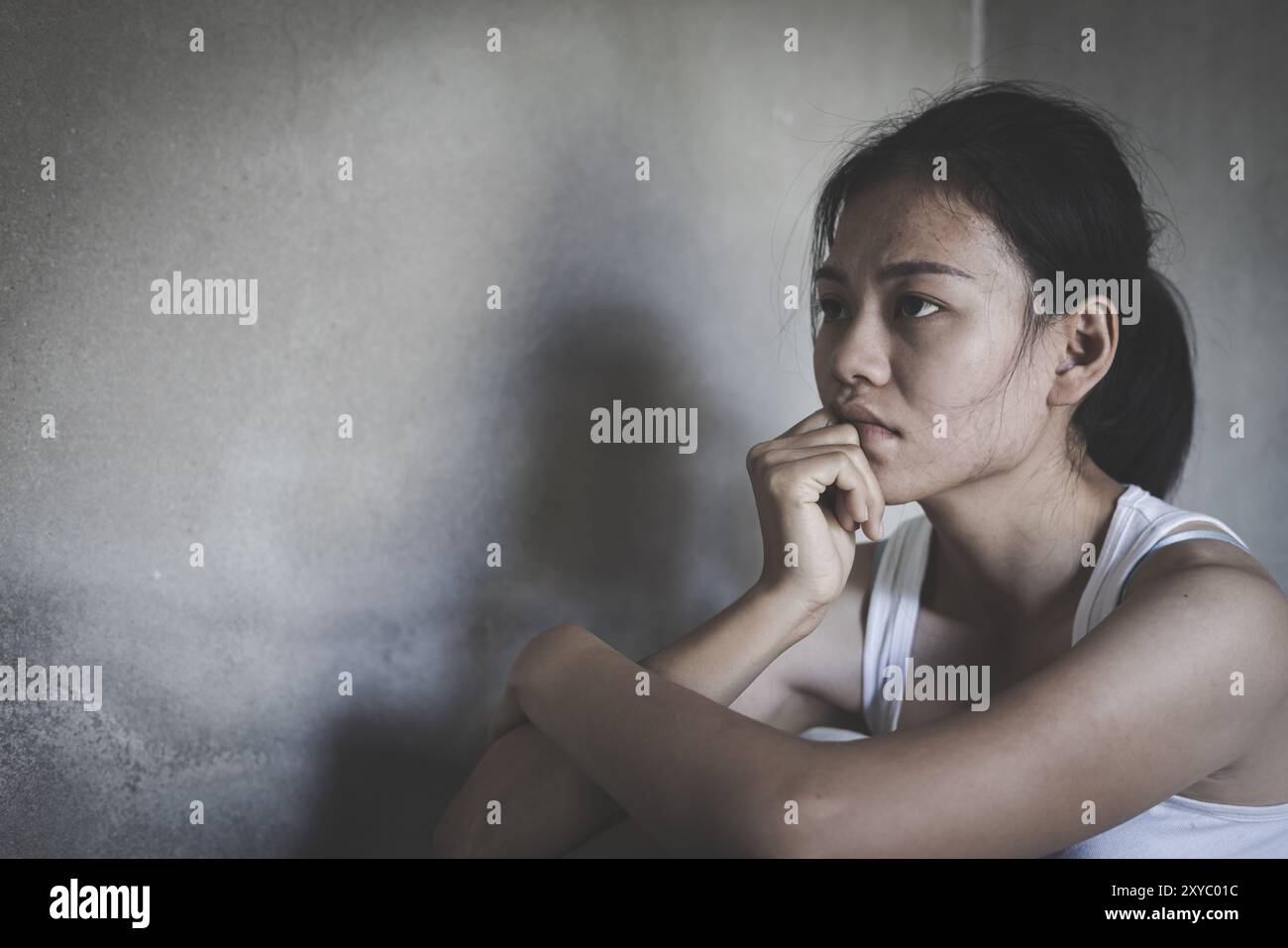 Depressed woman, person sitting alone on the floor felling sad worry. Stress, suicidal thoughts. Stock Photo