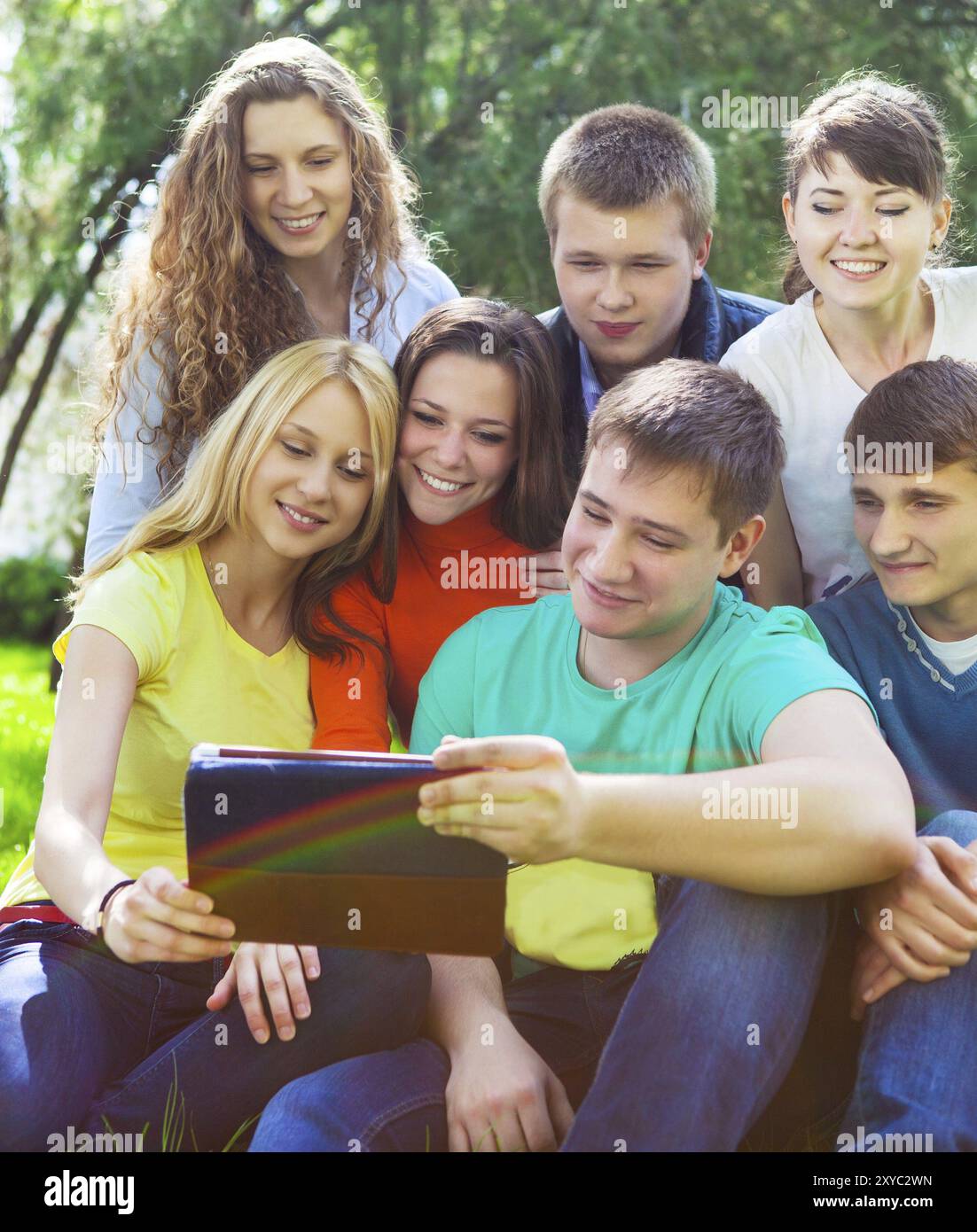 Young college students using tablet computer while doing homework in the park Stock Photo