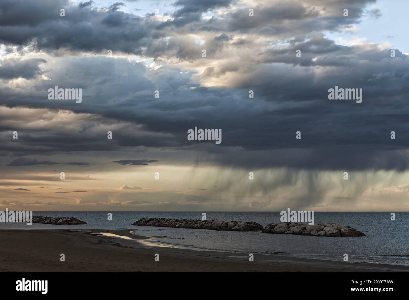 After a strong storm that moves away on the sea little by little the sky returns serene just before sunset Stock Photo