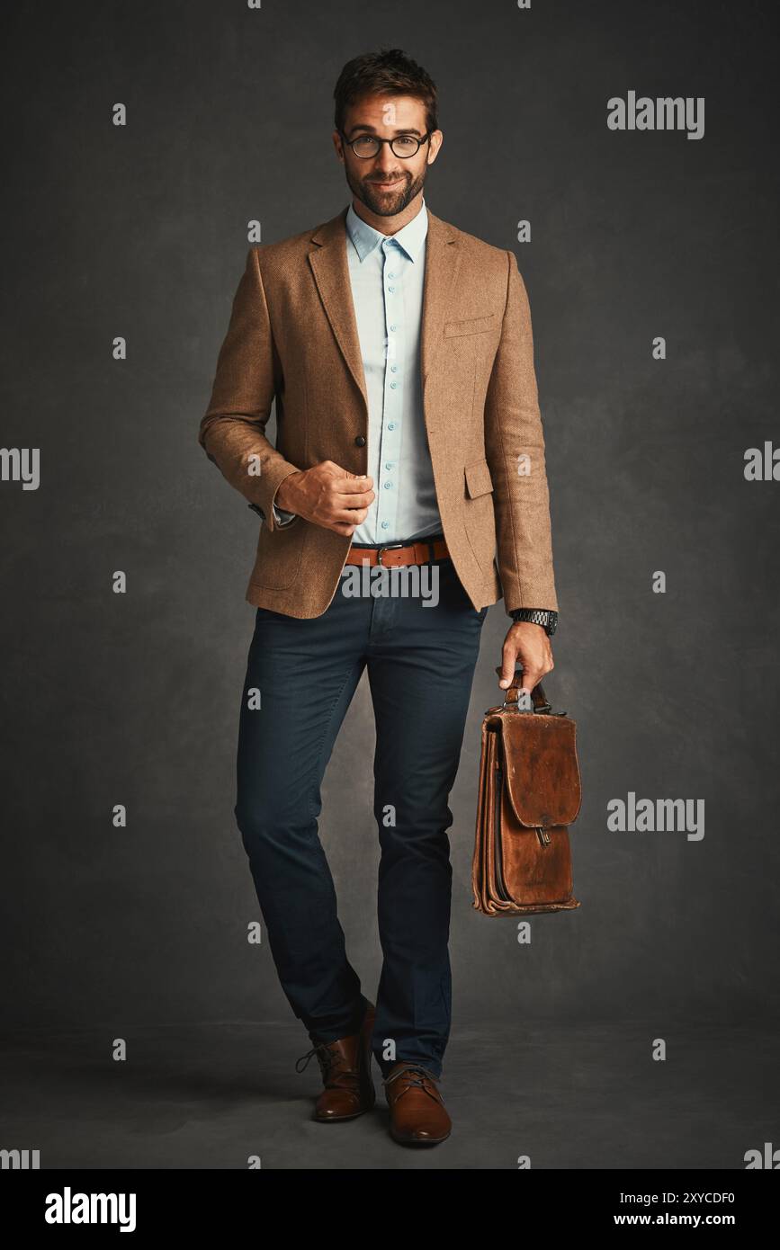 Briefcase education and portrait of professor man in studio on dark background for college lecture. Fashion glasses and walking with serious Stock Photo Alamy