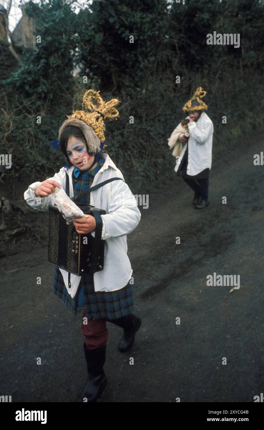 Irish Folklore Ireland 1970s, two Biddy Boys brother and sister dressed up and celebrating in the traditional way the Celtic Saint Brigit or Brigid, who was a goddess of pre-Christian Ireland. February 1st is her Saints Day. They are walking from one country cottage to another. Killorglin, County Kerry, Eire, Southern Ireland February 1972 Eire HOMER SYKES Stock Photo