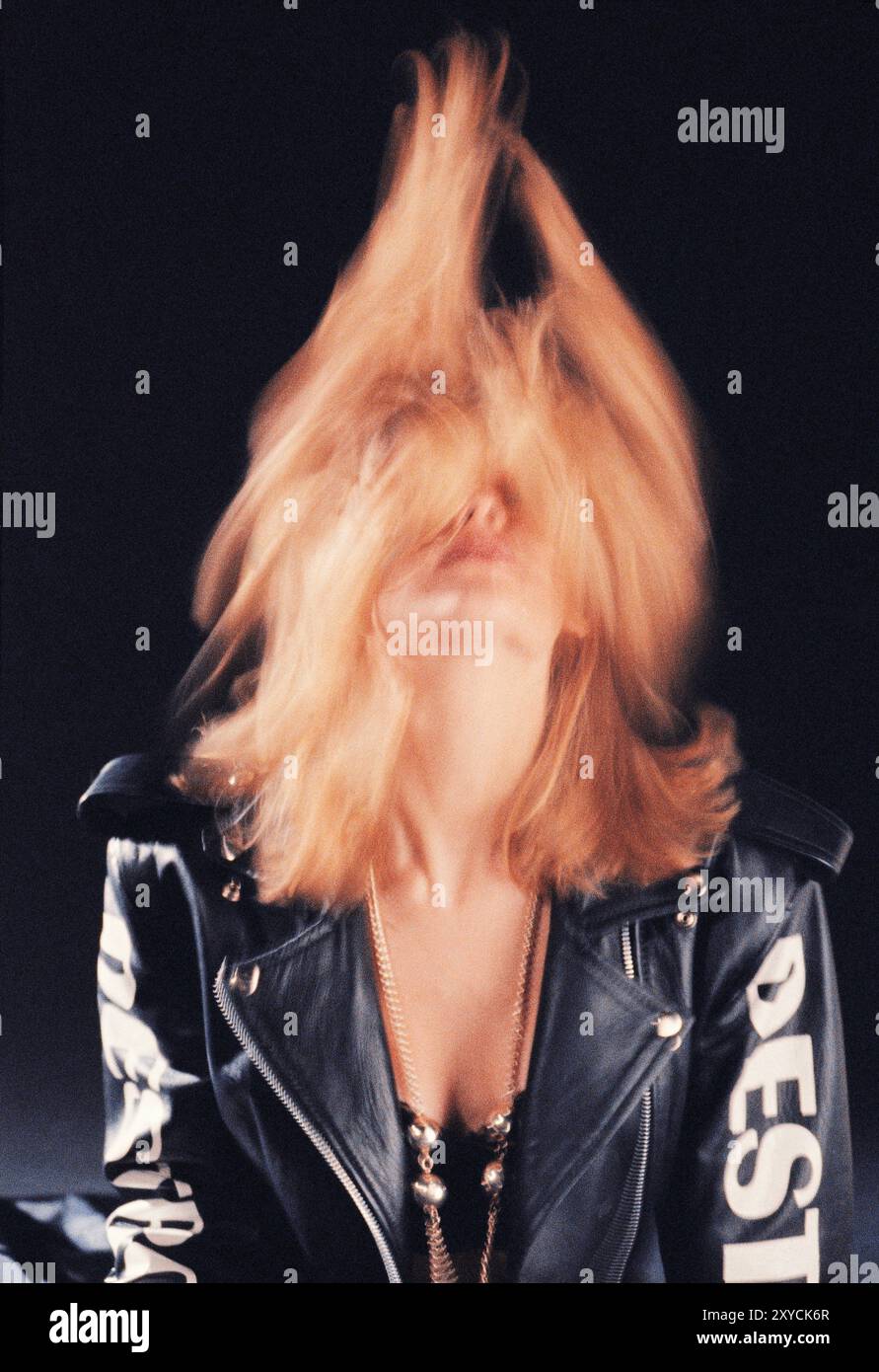 Studio portrait of young blond hair woman wearing black leather jacket. Stock Photo