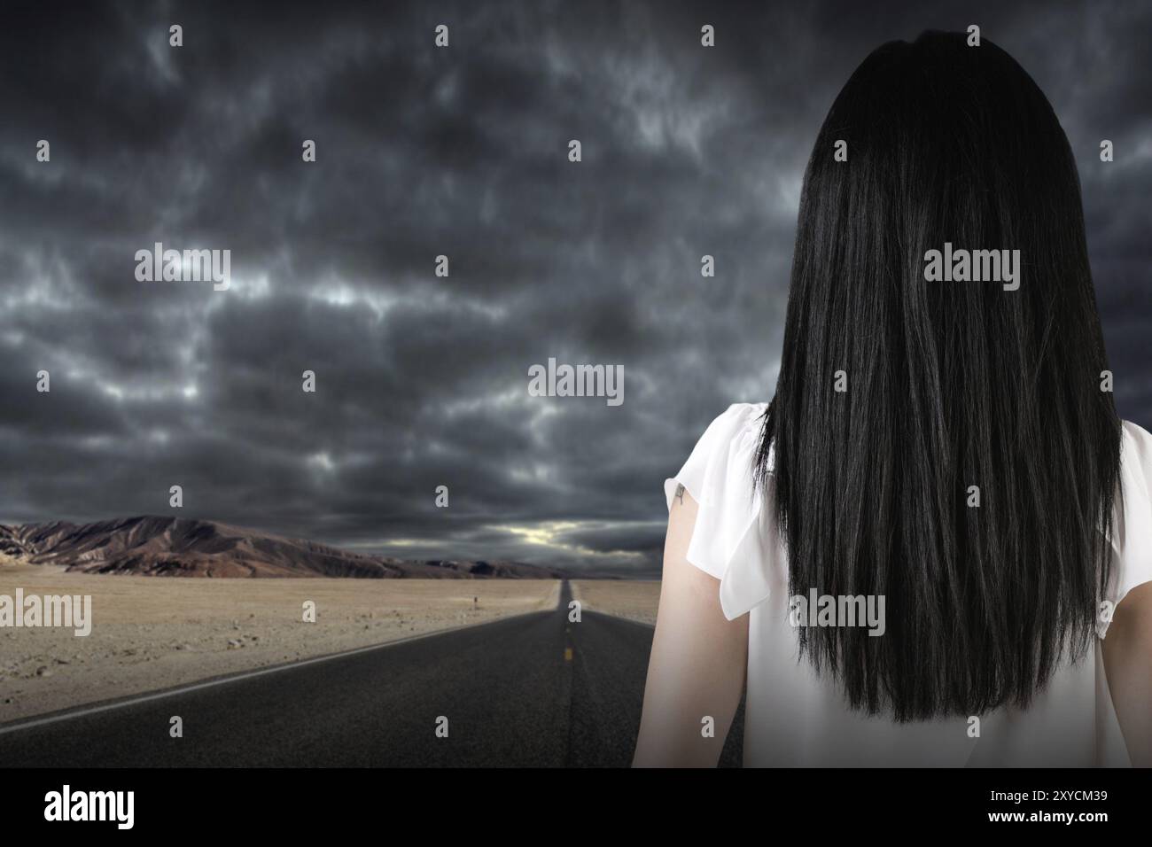 Businesswoman looking out a dark stormy road Stock Photo