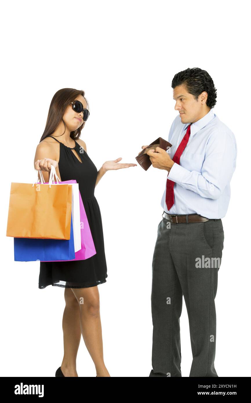 A greedy shopaholic gold digger superficial wife shrugging and demanding cash from her poor husband showing his empty wallet with no money. V Stock Photo