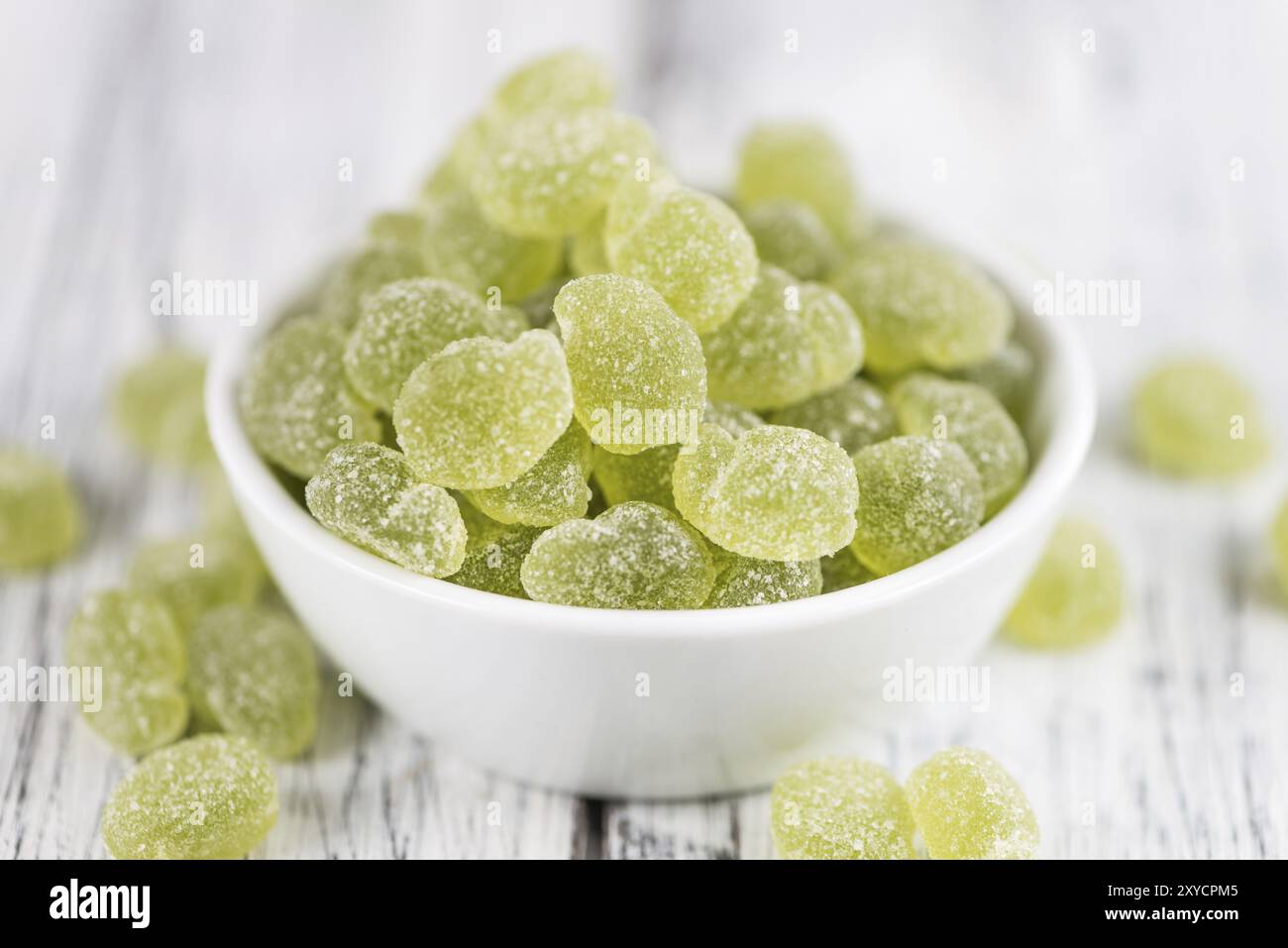Sour gummy candy (apple taste) on an old wooden table (selective focus) Stock Photo