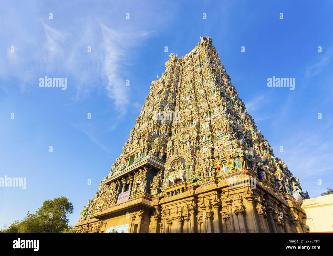 West tower gateway of Meenakshi Amman Temple covered in colorful statues of gods on a blue sky day at Madurai in south Indian state of Tamil Nadu, Ind Stock Photo