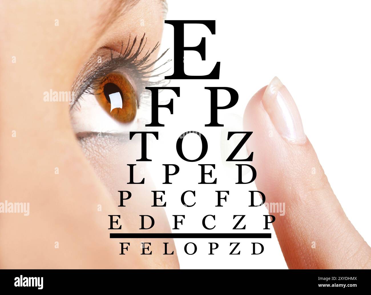 Closeup of a woman inserting a contact lens in her eye Stock Photo