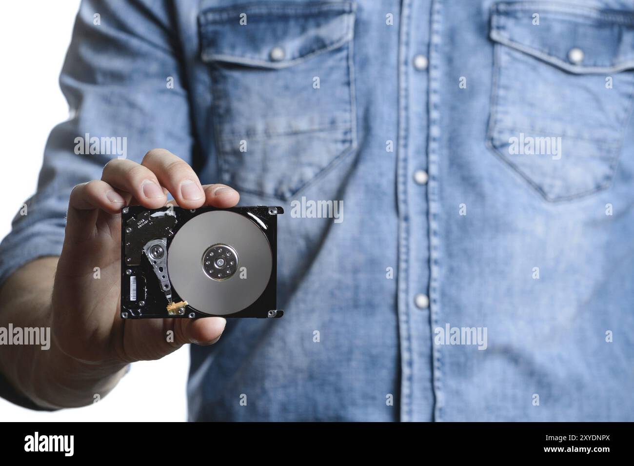 Man's hand holds a 2.5 inch hard drive. He's points to the hard disk. View of the backside HDD, from the PCB. Isolated on white background Stock Photo